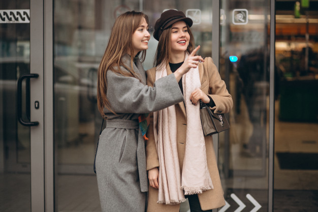 two-girls-outside-shopping-mall-in-an-autumn-day_1303-6436