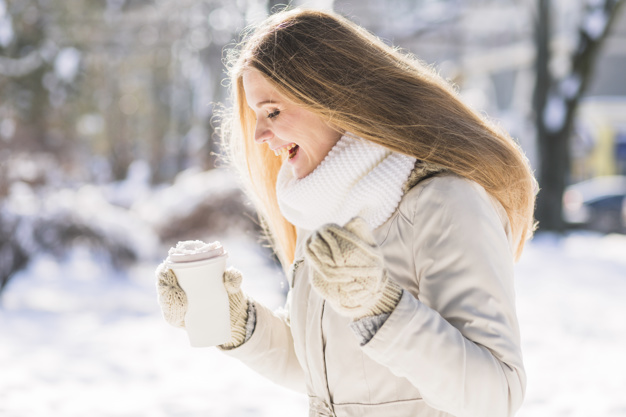 happy-female-veterinarian-holding-takeaway-coffee-cup-standing-in-snow_23-2147928548